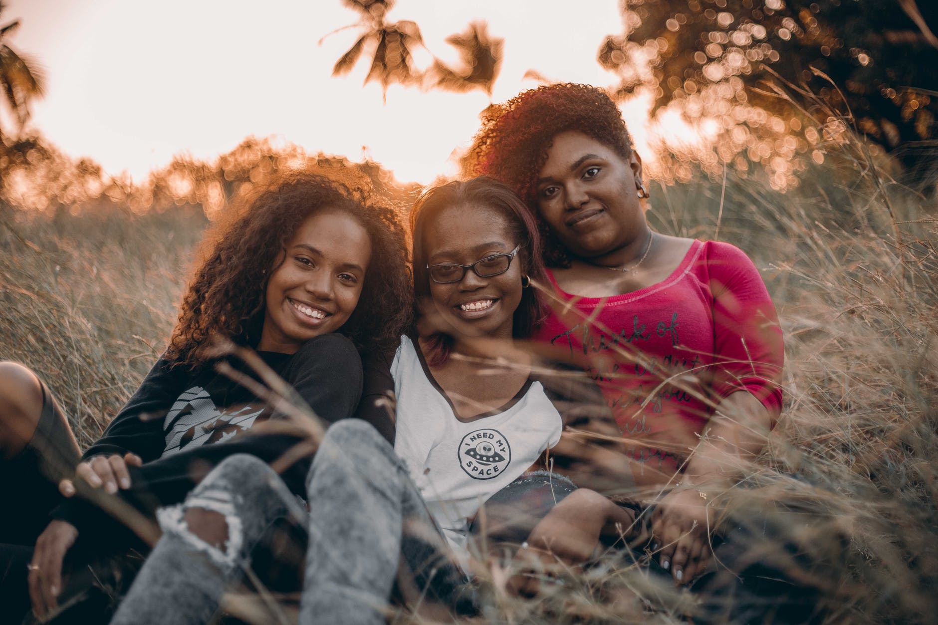 three women sitting on grass